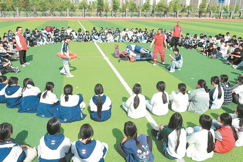 5月12日，在阜阳市第十五中学开发区分校操场上，志愿者正向学生传授防溺水自救互救知识与技能，进一步织密织牢夏季防溺水安全网。.jpg