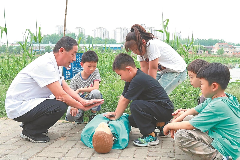 5月14日，滁州市南谯区乌衣镇柯湖村，医务志愿者在为小朋友讲解防溺水急救知识。志愿者通过“场景化教学+沉浸式体验”的方式，进一步增强未成年人防溺水安全意识。.jpg